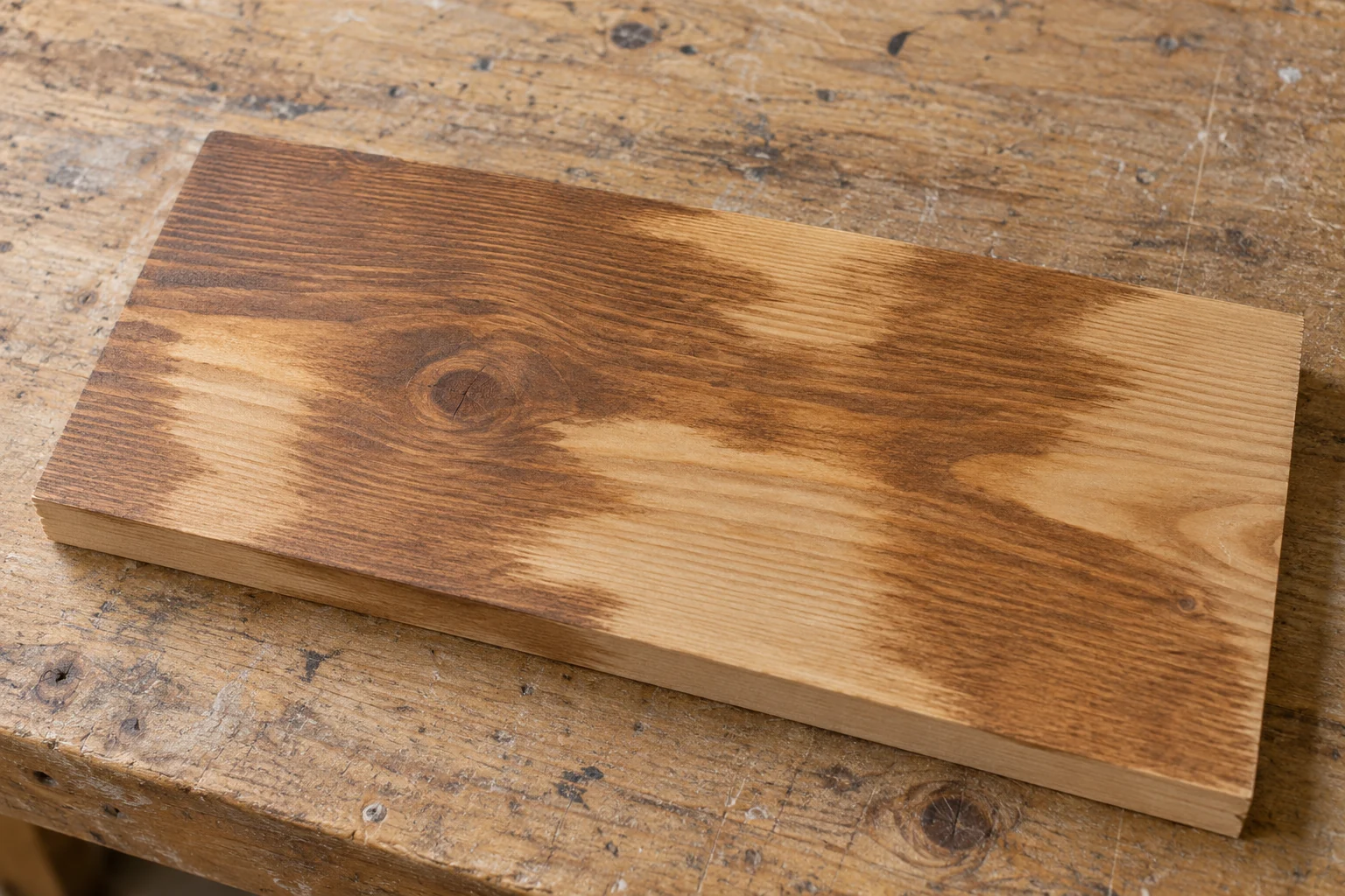 Dry stained pine with uneven light and dark areas following the grain